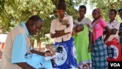 A health worker records information from patient's health passport in Balaka district in southern Malawi. Feared to be carriers of the coronavirus, some medical workers in Malawi have been increasingly shunned. (Lameck Masina/VOA)