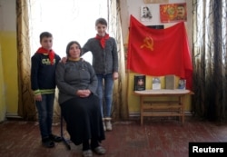 Natia Babunashvili, 40, an unemployed mother of two, poses for a portrait with her children Tamuna (R), 14, and Giorgi, 13, at her home in Tbilisi, Georgia, Nov. 24, 2016.