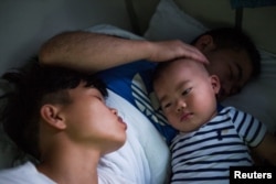 Huang Wensi and her husband travel for nearly a full day to bring their son back to their hometown where he will stay with his grandmother, in Lianjiang, Guangdong province, China, June 30, 2018.