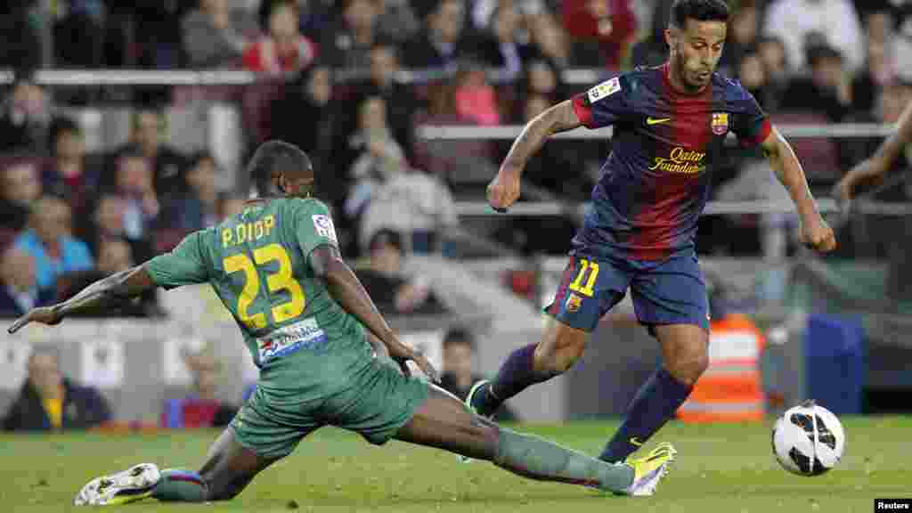 Barcelona&#39;s Thiago Alcantara (R) eludes Levante&#39;s Pape Diop during their Spanish First division soccer league match at Camp Nou stadium in Barcelona April 20, 2013.