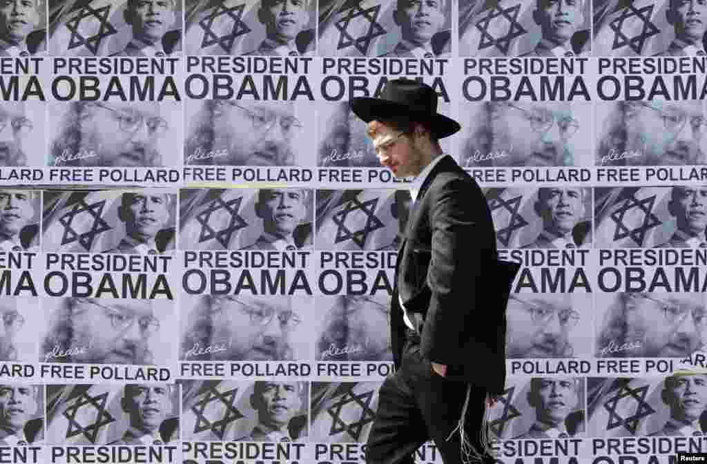 An ultra-Orthodox Jewish man walks past posters calling for U.S. President Barack Obama to free Jonathan Pollard from a U.S. prison, in Jerusalem, March 20, 2013.