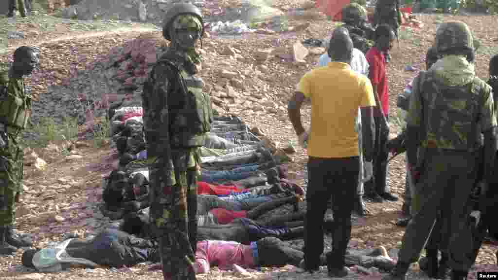 Des militaires kenyans ainsi que des volontaires de la Croix-Rouge portent des corps des personnes tuées dans une carrière au village Korome, en dehors de la ville frontalière de Mandera, au Kenya, le 2 décembre 2014.