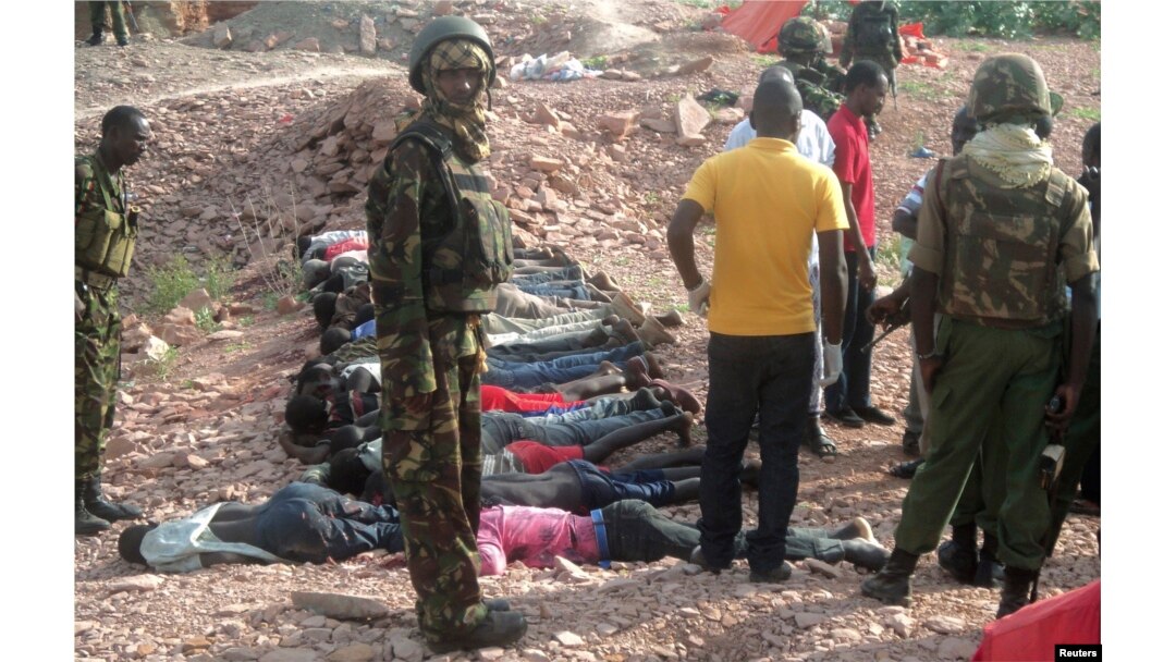 FILE - Kenyan military personnel stand near bodies lined up on the ground at a quarry site where attackers killed at least 36 workers in a village in Korome, outside the border town of Mandera, Dec. 2, 2014.