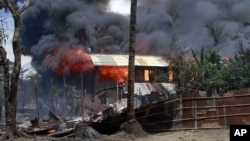 Khói bốc lên từ 1 căn nhà đang cháy ở Sittwe, Rakhine, Miến Điện, nơi bạo động giáo phái đang diễn ra, 12/6/2012
