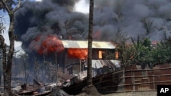 Smokes and flames billow from burning buildings in Sittwe, capital of Rakhine state in western Burma, where sectarian violence is ongoing, June 12, 2012.