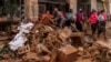 People clean mud from a shop affected by floods in Chiva, Spain, on Nov. 1, 2024.