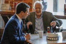 Democratic presidential candidate former South Bend, Ind., Mayor Pete Buttigieg, left, meets with former President Jimmy Carter, center, at Buffalo Cafe in Plains, Ga., March 1, 2020.