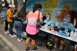Migrant workers register for Covid-19 testing in the Central district of Hong Kong on May 1, 2021, after the government ordered the tests after two domestic workers were found to be infected with a more infectious variant.