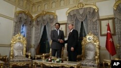 FILE - Turkish President Recep Tayyip Erdogan, right, and Qatar's Emir Sheik Tamim bin Hamad Al Thani shake hands as they pose for a photo at the Mabeyn Palace, one of old Ottoman palaces in Istanbul, Friday, Feb. 12, 2016.