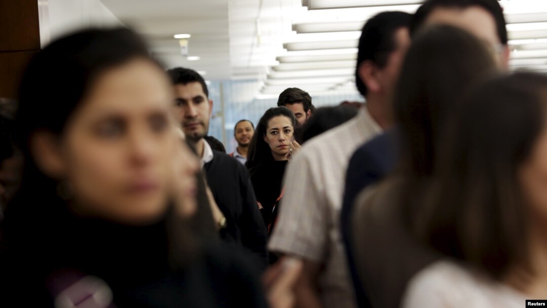 Employees of an office stand ready to evacuate the building after a tremor was felt in Mexico City, Nov. 23, 2015. 