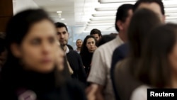 Employees of an office stand ready to evacuate the building after a tremor was felt in Mexico City, Nov. 23, 2015. 