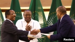 L'ancien président kenyan Uhuru Kenyatta applaudit le représentant du gouvernement éthiopien Redwan Hussien et le délégué du Tigré Getachew Reda, à Pretoria, le 2 novembre 2022.