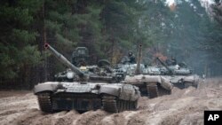 Фото 28 жовтня 2022 року. Українські військові на російських танках проводять військові навчання поблизу кордону з Білоруссю (AP Photo/Aleksandr Shulman)