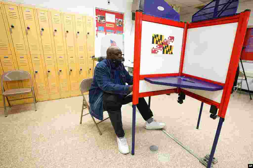 A man fills out a ballot during early voting at Westside Skill Center, Monday, Oct. 31, 2022, in Baltimore, Md.