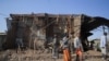 FILE - Residents and militias stand next to houses destroyed by an airstrike during the fight between the Ethiopian National Defence Forces (ENDF) and the Tigray People's Liberation Front (TPLF) forces in Kasagita town, Afar region, Ethiopia, Feb. 25, 2022.