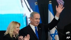 Benjamin Netanyahu, mantan PM Israel dan ketua partai Likud, didampingi istrinya Sara melambaikan tangan kepada para pendukungnya setelah hasil exit poll pertama untuk pemilihan Parlemen Israel di markas partainya di Yerusalem, 2 November 2022. (AP/Tsafrir Abayov)