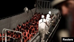 Migrants are rescued by staff members of the MV Aquarius, a search and rescue ship run in partnership between SOS Mediterranee and Medecins Sans Frontieres in the central Mediterranean Sea, June 10, 2018. (Karpov/handout via Reuters)