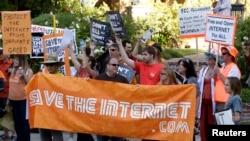 FILE - Pro-net neutrality activists rally in the neighborhood where then-President Barack Obama attended a fundraiser in Los Angeles, July 23, 2014.