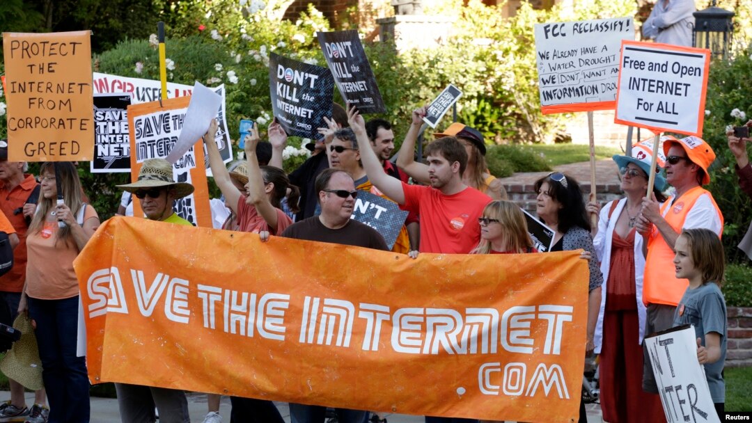 FILE - Pro-net neutrality activists rally in the neighborhood where then-President Barack Obama attended a fundraiser in Los Angeles, July 23, 2014.
