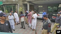 Pakistani security officials gather at the compound of the house of a abducted American citizen in Lahore, Pakistan, Aug. 13, 2011.