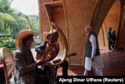 Perdana Menteri India Narendra Modi berjalan melewati orang-orang yang memainkan alat musik saat makan siang para pemimpin di KTT G20 di Nusa Dua, Bali, 15 November 2022. (Foto: REUTERS/Ajeng Dinar Ulfiana)
