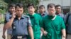 FILE - A Japanese doctor, front right, and the chief security officer of the Japanese Embassy in Bangladesh, center, walk back from the morgue after the autopsy on the body of Kunio Hoshi at Mahiganj village, 300 kilometers north of Dhaka, Oct. 4, 2015.