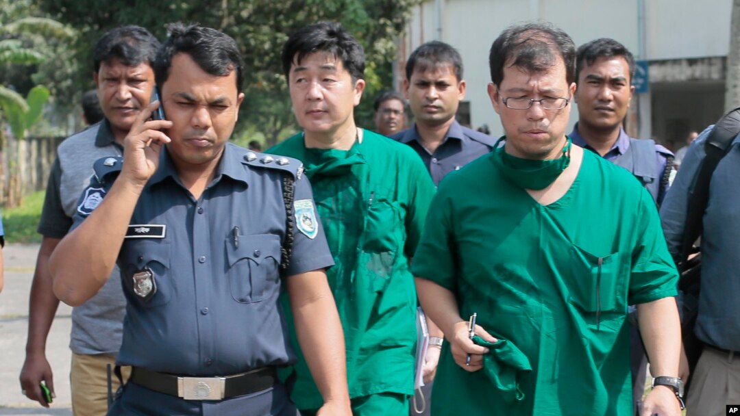 Bác sĩ Nhật Bản và quan chức an ninh của tòa đại sứ Nhật ở Bangladesh sau khi khám tử thi công dân Nhật Kunio Hoshi tại làng Mahiganj, quận Rangpur, Bangladesh, ngày 4/10/2015.