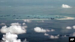 This photo taken through a window of a military plane shows China's apparent reclamation of Mischief Reef in the Spratly Islands in the South China Sea, May 11, 2015. (Ritchie B. Tongo/Pool Photo via AP)