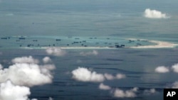 This photo, taken on May 11, 2015, through a window of a military plane shows China's apparent reclamation of Mischief Reef in the Spratly Islands in the South China Sea. (Ritchie B. Tongo/Pool Photo via AP)