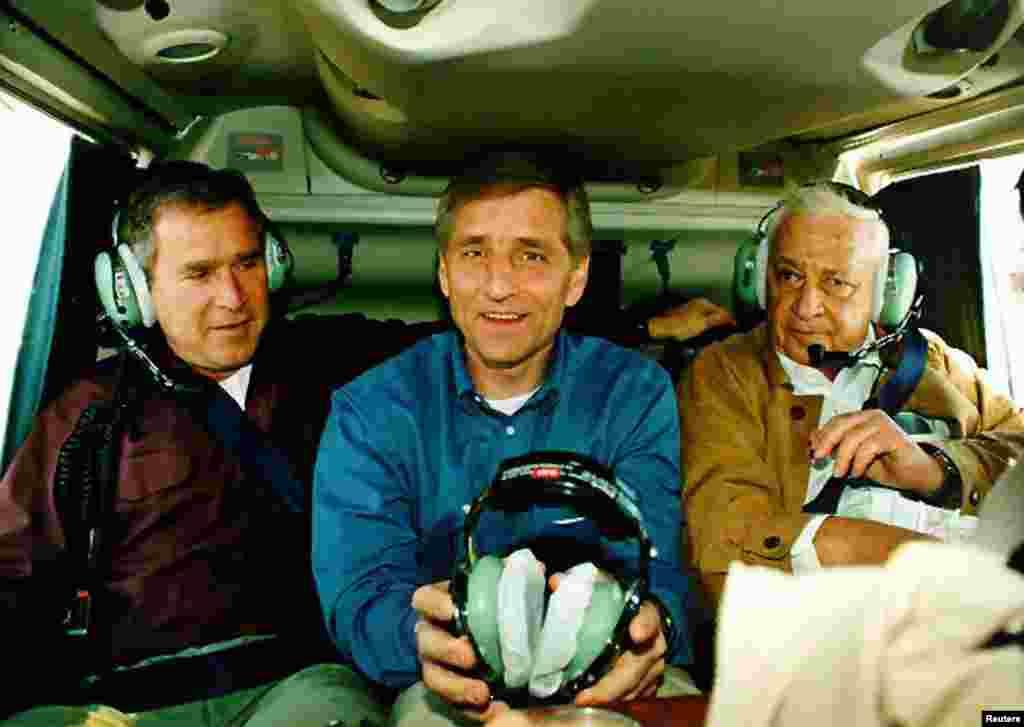 O ministro da Defesa israelita, Ariel Sharon, viaja um helicóptero com o governador&nbsp;George Bush d o governador Mike Leavitt de Utah numa viagem sobre os territórios de Israel e West Bank territories, Dez. 1, 1998. 