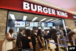 People queue at a Burger King fast food restaurant during inauguration of first Carrefour supermarket of Sub-Saharan Africa in Abidjan on Dec. 18, 2015.