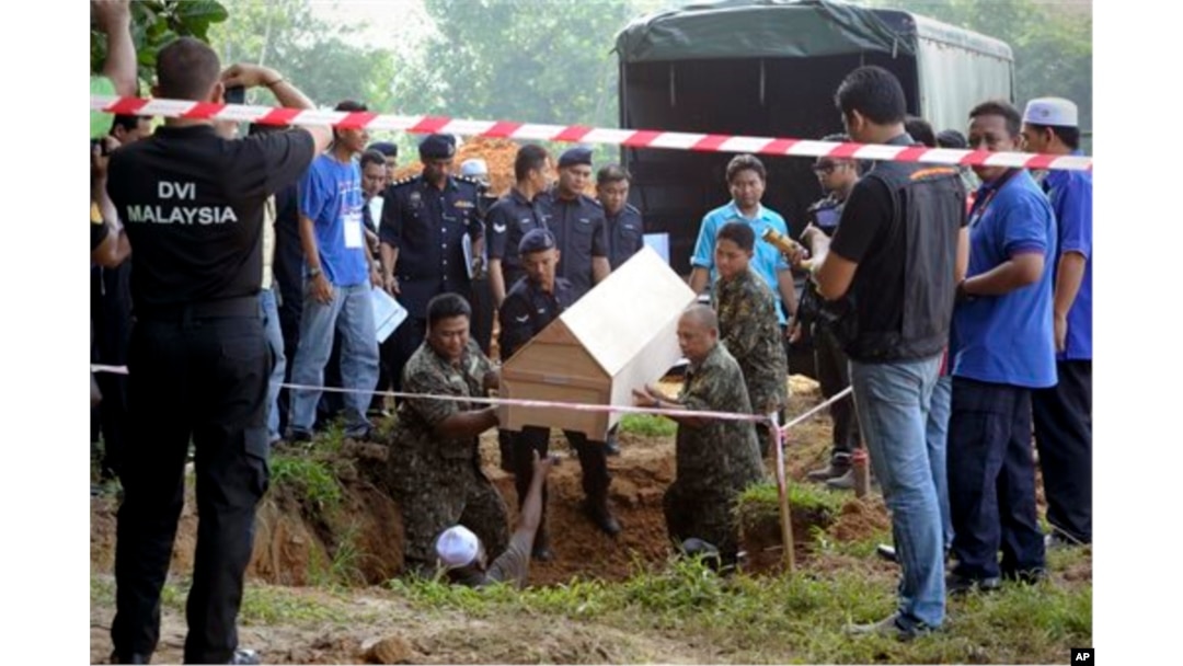 FILE - Malaysian officials provide Muslim burial to 21 human trafficking victims, believed to be Rohingya Muslim refugees, found in shallow graves in jungles bordering Thailand, in Kedah, Malaysia, June 22, 2015.