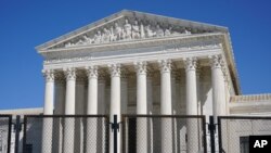 FILE - Security fencing surrounds the Supreme Court building on Capitol Hill in Washington, Sunday, March 21, 2021.