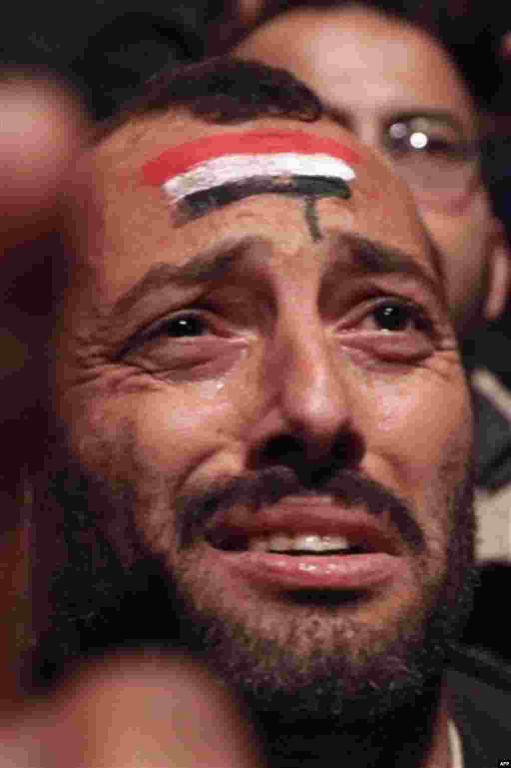 A protester is overcome by emotion as he and others prematurely celebrate prior to the televised speech of Egyptian President Hosni Mubarak, in which they believed he would step down, at the continuing anti-government demonstration in Cairo, Egypt Thursda