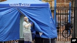 Medical works operate a testing tent at a COVID-19 mobile testing site, Nov. 11, 2020, in the Brooklyn borough of New York.