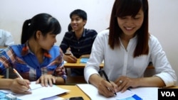Pham Thi Trang, right, studies Japanese at a free language school set up by a street vendor in Hanoi, Vietnam, Aug. 7, 2014. 