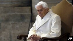 FILE - Pope Emeritus Benedict XVI sits in St. Peter's Basilica as he attends a ceremony marking the start of the Holy Year, at the Vatican, Dec. 8, 2015. 