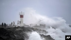 Waves crash onto rocks as people look on at the Spit, on the Seaway on the Gold Coast, Australia, March 3, 2025, as Cyclone Alfred builds off the east coast.