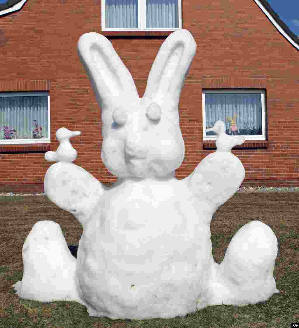 An Easter bunny made of snow is placed in a garden in Oster-Ohrstedt, northern Germany.