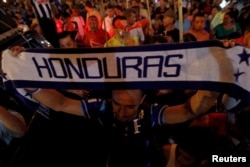 FILE - A demonstrator holds up a scarf during a march to demand the resignation of Honduras' President Juan Orlando Hernandez in Tegucigalpa, Sept. 11, 2015.