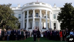 President Donald Trump and first lady Melania Trump stand for a moment of silence to mark the anniversary of the Sept. 11 terrorist attacks, on the South Lawn of the White House, Sept. 11, 2017, in Washington. 