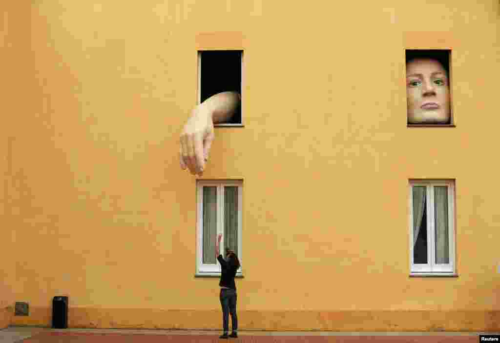 A woman takes pictures of art installation &quot;Alice&quot; by Spanish artist Cristina Lucas in the Andalusian Center of Contemporary Art in the Andalusian capital of Seville, southern Spain, April 10, 2013. 