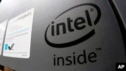 FILE- This Jan. 1, 2018, file photo shows an Intel logo on the box containing an HP desktop computer on sale at a Costco in Pittsburgh.