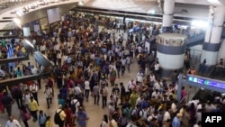 FILE - Commuters make their way through a metro station at rush hour in New Delhi, India, July 11, 2016.