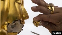 A craftsman fixes the statue of Hindu god Brahma after it was damaged during the deadly blast at the Erawan shrine in Bangkok, Thailand, August 26, 2015. 