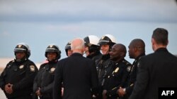 FILE —US President Joe Biden shakes hands with motorcycle police before departing at Atlanta Hartsfield-Jackson International Airport in Atlanta, Georgia, on March 9, 2024.