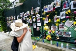 People embrace at a makeshift memorial for people dead or missing after the collapse of a condominium building, in Surfside, Florida, June 28, 2021.