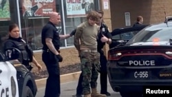 A man is detained following a mass shooting in the parking lot of TOPS supermarket, in a still image from a social media video in Buffalo