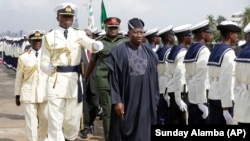 FILE - Nigeria President Goodluck Jonathan inspects the honor guard at a naval warship commissioning event in Lagos, Feb. 19, 2015.