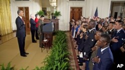 President Barack Obama says the Pledge of Allegiance during a naturalization ceremony for active duty service members in the East Room of the White House, July 4, 2012. 